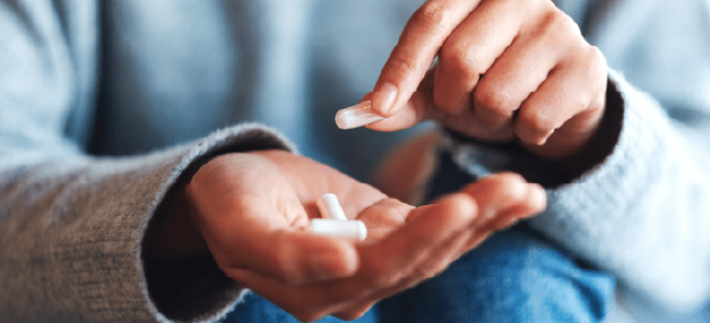 Person holding white pills